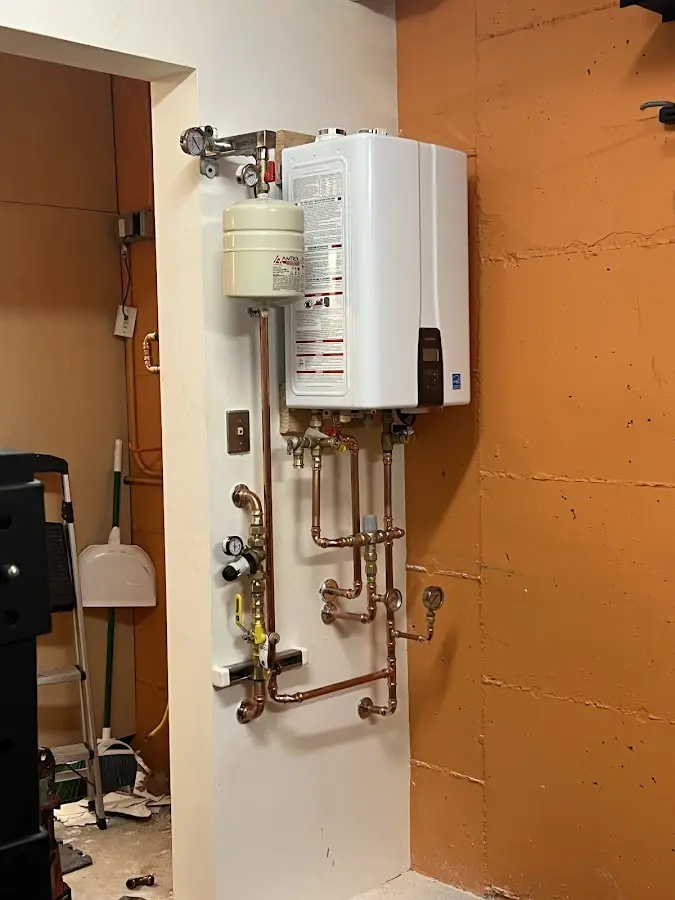 Plumbing technician inspecting water heater connections in Bangor